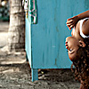 photo: Curly - A young Balinese girl surveys the scene on her father's lap at Kuta beach in Bali.