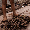Metal Worker Photo: A young boy takes a break from repeatedly lifting and dropping a set of chains.