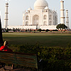 Inside Outside Photo: A young lady reads on a park bench at the Taj Mahal.