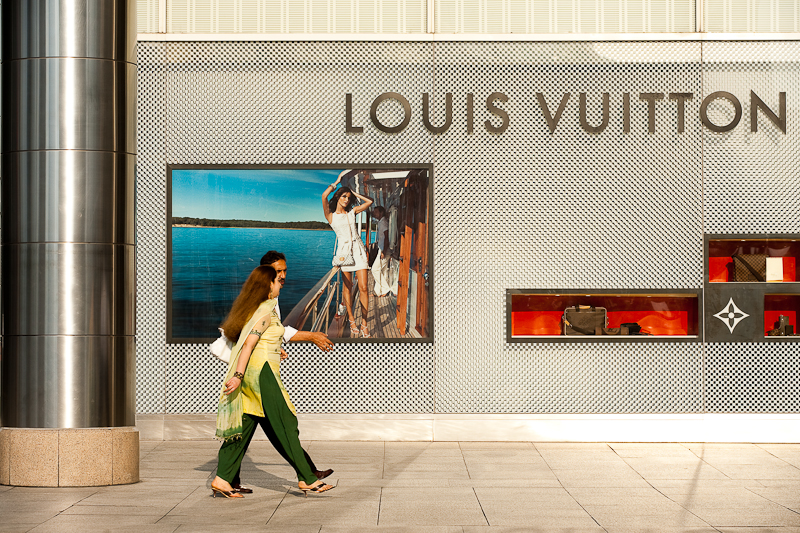 A pair of ethnic Indian-Malaysians walk in front of a Louis Vuitton store. - Kuala Lumpur, Malaysia - Daily Travel Photos