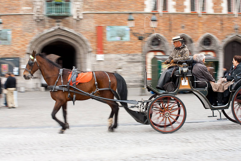 A tourist horse and buggy glide past the belfry on Grote Markt. - Brugge, Belgium - Daily Travel Photos