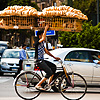 Amazing Acrobatics Photo: A bicycle bread delivery guy steadies a rack of bread with one hand through Cairo traffic.
