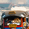 Traditional Taxi Photo: An air-polluting tuk-tuk heads outbound from downtown Bangkok.