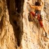 photo: Railay Rock Climbing - A female rock-climber framed by stalactites.