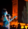Female Thai Singer Photo: A female Thai singer is seen projected onto a TV screen in the background at an open-air performance in Bangkok.