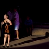 photo: Female Thai Violinist - A Thai violinist reacts to an audience member at an open-air show in Bangkok.