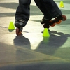 Slick Skating Photo: A spot-lighted slalom skating competitor slides backwards through small pylons at Central World Mall.