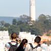 Opposite Overlook Photo: Tourists photographing Coit Tower from the top of Lombard Street in San Francisco.